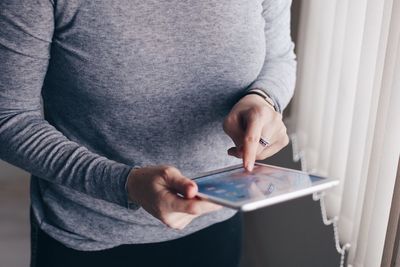 Midsection of man using mobile phone