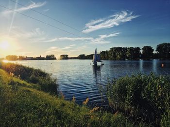 Scenic view of river against sky at sunset