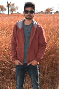 Portrait of young man standing on field