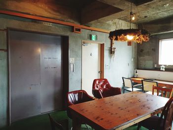 Empty chairs and tables in illuminated room