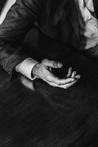 Cropped hand of man gesturing on wooden table