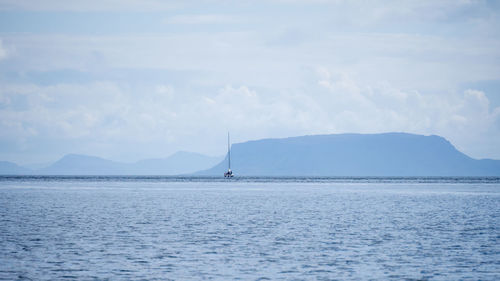 Sailboat sailing on sea against sky