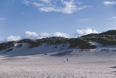 Sand hill against sky at desert on sunny day