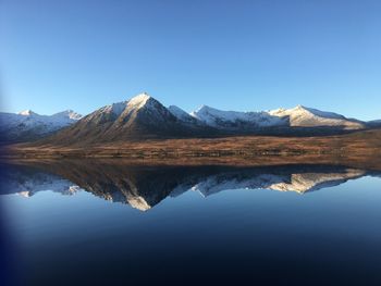 Reflection of mountains in lake against clear blue sky