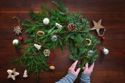 Cropped hand of woman decorating christmas tree