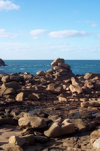 Rocks on sea shore against sky