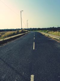 Surface level of country road against clear sky