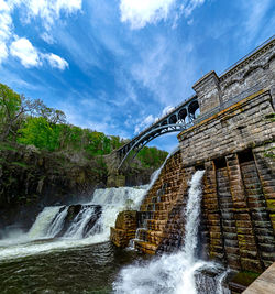 Low angle view of waterfall against sky