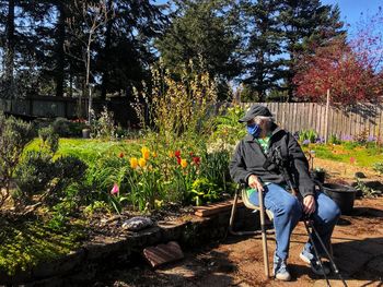 Full length of woman sitting on seat in park