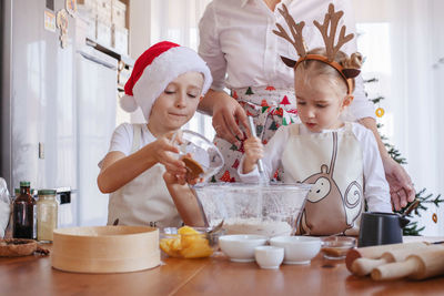 Midsection of mother teaching kids cooking