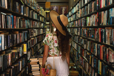 Rear view of woman wearing hat in library