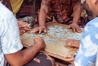 Midsection of people playing cards