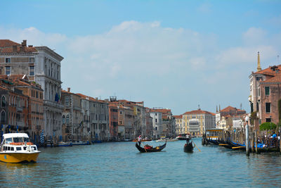 Boats in canal amidst buildings in city