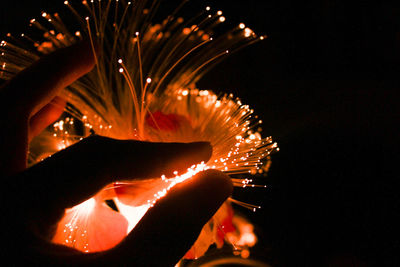 Close-up of hand holding illuminated decoration at night