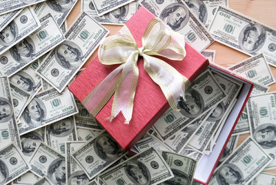 High angle view of gift box with paper currencies on table