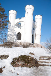 Low angle view of snow covered buildings against sky