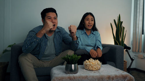 Young couple sitting on sofa at home