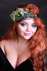 Close-up portrait of sensuous young woman against black background