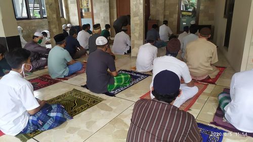 Rear view of people sitting in temple