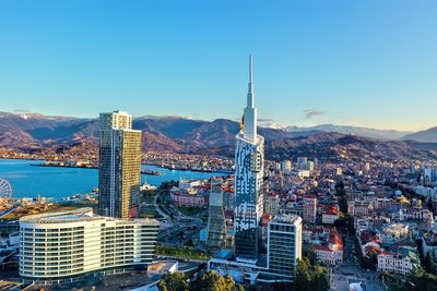 Aerial view of city buildings against blue sky