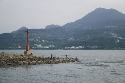 Scenic view of sea and mountains against sky