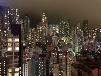 Illuminated buildings in city against sky at night