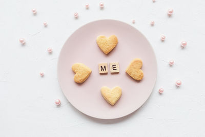 Me word and heart shaped cookies on a pink plate