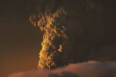 Firework display against sky at sunset