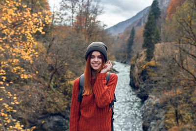 Portrait of a smiling young woman standing during autumn