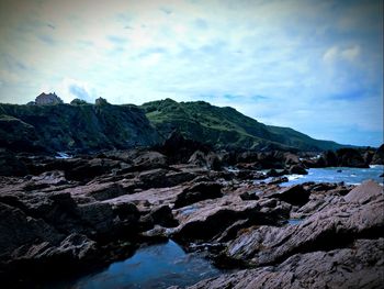 Scenic view of sea and mountains against sky