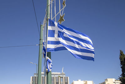 A greek flag flying from a post on a street in central athens, greece