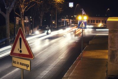 Road sign on street at night