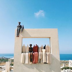 Rear view of people at beach against sky