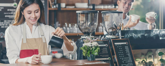 Young woman holding drink in restaurant