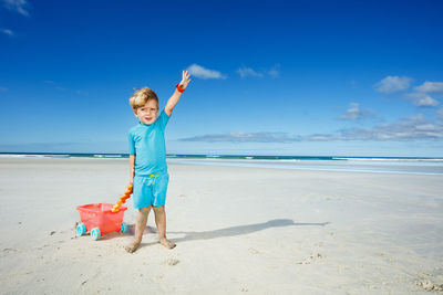 Full length of boy standing at beach