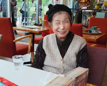 Portrait of smiling woman sitting on table in restaurant