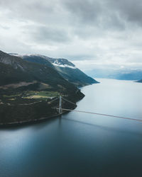 Bridge over sea against cloudy sky