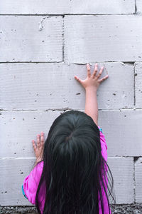 Rear view of woman against pink wall