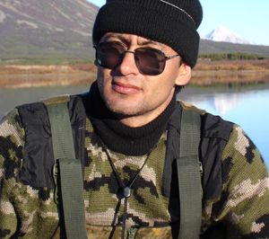 Portrait of young man standing by lake