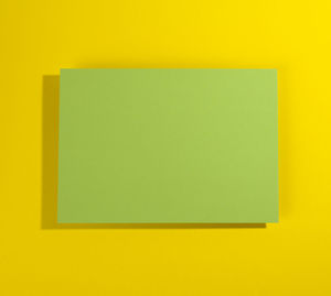 Close-up of yellow paper over colored background