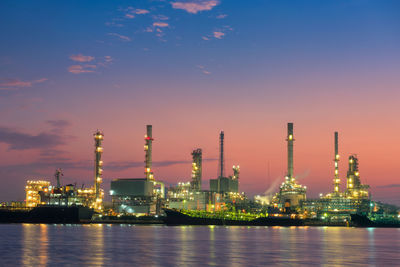 Illuminated factory against sky at night