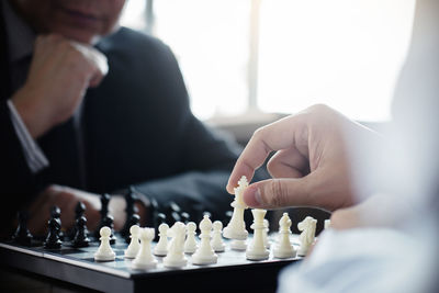 Midsection of businessmen playing chess