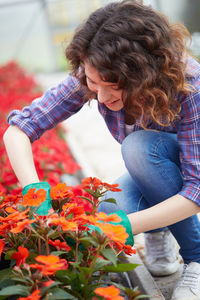 Woman holding flower pot at greenhouse