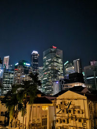Illuminated buildings in city against sky at night