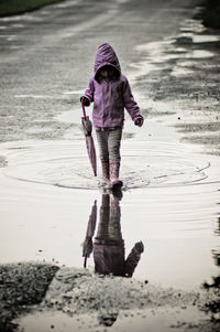 Full length of woman walking in puddle