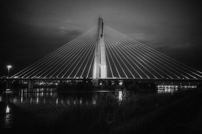 Bridge over river against sky at night