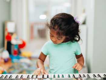 Cute girl learning piano at home