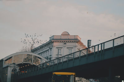 Low angle view of bridge and buildings against sky