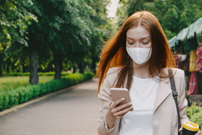 Young woman using smart phone outdoors