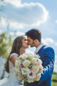 View of bride and groom holding bouquet